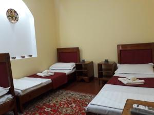 布哈拉Amir-Yaxyo Hotel的一间设有两张床的房间和一张地毯