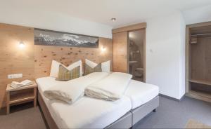 索尔登Garni Ötztal ROOMS & APARTS的卧室配有一张带白色床单和枕头的大床。