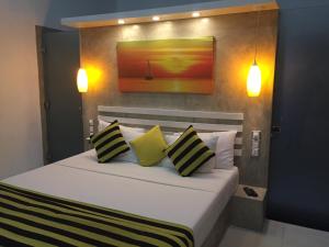 尼甘布多米尼库住宿加早餐旅馆的一间卧室配有一张带黄色和黑色枕头的床