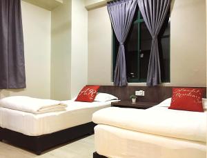 马六甲Amadel Residence 爱媄德民宿 1314的带窗户的客房内的两张床和红色枕头