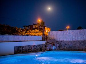 利帕里Odysseus Hotel的夜晚的游泳池,天空中月亮
