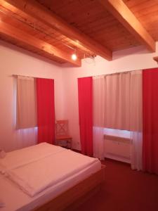 伊布斯河畔格施特灵Ferienhof Kirchau的一间带红色窗帘和床的卧室