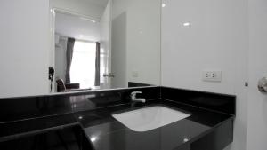 南芭堤雅海洋明珠酒店的黑白浴室设有水槽和镜子