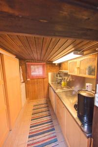 诺尔泰利耶Egen stuga med delat badrum的一间带木制橱柜和地毯的小厨房