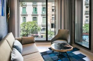 马德里The Garden Suites的带沙发和椅子的客厅以及大窗户。