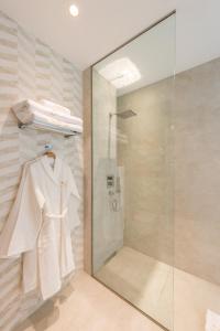 马德里The Garden Suites的带淋浴和白色浴袍的浴室