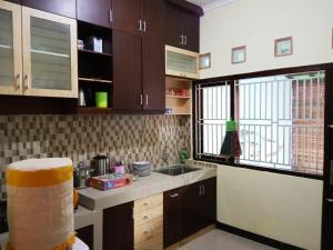 直葛Homestay Tegal Kota by Simply Homy的厨房配有棕色橱柜、水槽和窗户。