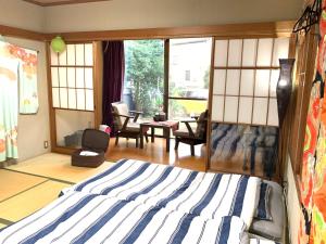 八千代市Koto House的一间卧室设有一张床和一间客厅。