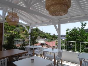 帕蒂迪里奥Galini Hellenic Hospitality的庭院内带桌椅的白色凉亭