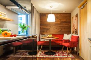 圣安东阿尔贝格Quality Hosts Arlberg - Lärchenhof的一间用餐室,配有红色的椅子和桌子