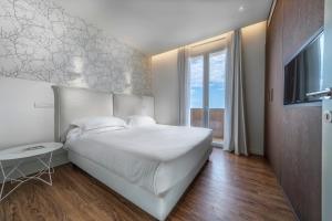 里乔内Hotel Select Suites & Spa - Apartments的卧室设有一张白色大床和一扇窗户。