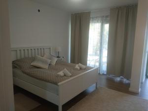 MurineApp Neno的卧室配有带枕头的床铺和窗户。