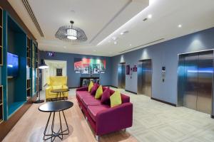 迪拜迪拜国际机场普瑞米尔酒店的客厅配有紫色沙发和黄色椅子