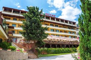 韦林格勒SPA Hotel Olymp的一座酒店大楼,上面有标志