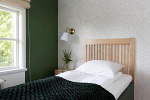 JärpenHotel Kallgården的卧室内的一张床位,卧室设有绿色的墙壁
