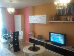 奥罗佩萨德尔马Residencial Algaida的客厅配有电视和带桌子的桌子。