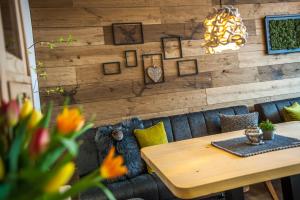 圣安东阿尔贝格Quality Hosts Arlberg - Lärchenhof的一间带桌子和木墙的用餐室