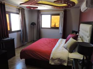 瓦迪穆萨Valentine Inn Luxury的一间卧室配有一张带红色棉被的床和窗户