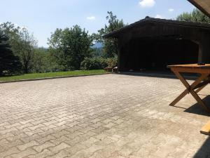 佐尔尼耶戈迪Apartment Tosca near Vintgar and Lake Bled的建筑前方带野餐桌的砖砌庭院