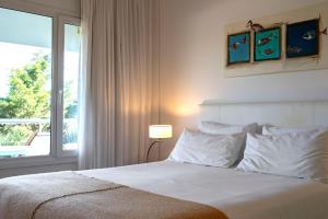 瓦勒里亚德玛瓦莱里娅海滩公寓的卧室配有白色的床和窗户