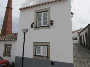 阿尔梅达Casa do Forno的白色的建筑,在街上有两扇窗户