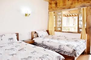 剑川县剑川沙溪游子闲庭客栈的一间卧室设有两张床和窗户。