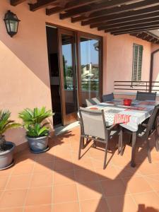 佩斯基耶拉德加达Esclusivo trilocale con piscina al Garda Resort Village的庭院里的餐桌和椅子