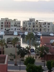 亚喀巴Sea View Apartment at Tala Bay Resort in Aqaba的享有拥有建筑和棕榈树的城市美景
