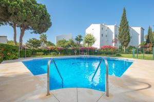 卡拉德米哈斯Beach Apartment Las Acacias Torrenueva的一座种有树木和花卉的公园内的游泳池
