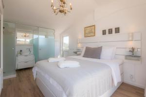卢斯Casa Luisandra Boutique Hotel B&B的白色的卧室配有一张白色的大床和镜子