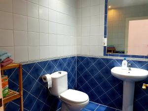 莫甘海滩Lina Mogan的蓝色瓷砖浴室设有卫生间和水槽