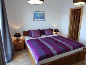 拉茨斯切THE VIEW ****的一间卧室配有一张带紫色床单的床和两盏灯。