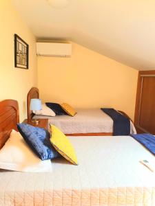 蓬德利马Casa Límia的一间卧室配有两张带枕头的床。