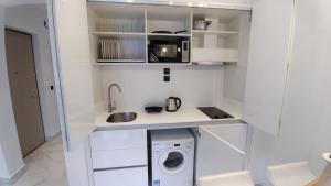 卡利塞亚-豪客迪克斯OpenSky Pool的一间白色的小厨房,内配洗衣机