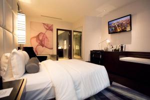 芝加哥常春藤精品酒店的卧室配有白色的床和墙上的电视。