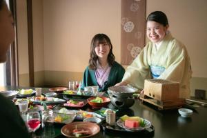 大津琵琶湖花街道旅馆的坐在餐桌旁吃饭的男人和女人
