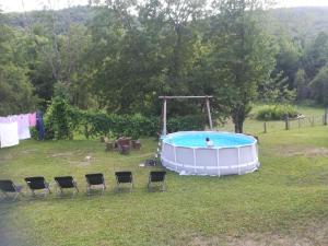德雷兹尼克格雷德Guesthouse Bubalo的院子里的游泳池,里面摆放着椅子,还有一个人