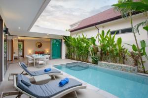 拉威海滩Villa Karina的庭院设有游泳池、椅子和桌子。
