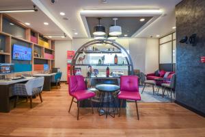 迪拜Premier Inn Dubai Al Jaddaf的一间带粉色椅子的餐厅和一间酒吧