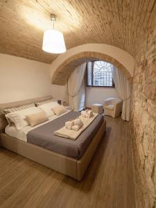 阿西西Residenza Porta Perlici Assisi Apartment的一间卧室设有一张带石墙的大床