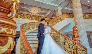 Ta Lan ThanHoang Nham Luxury Hotel的一位新娘和新郎沿着楼梯走下