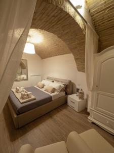 阿西西Residenza Porta Perlici Assisi Apartment的一间卧室设有一张床和砖墙