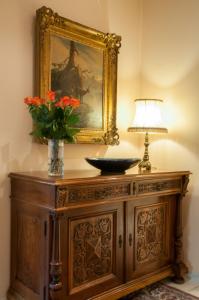 韦吉斯美岸韦吉斯罗曼蒂克酒店 - 美岸系列的木柜上一束花瓶,上面有灯