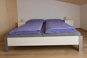 迈林根Ferienwohnung Gemeindematte的床上有两张紫色枕头