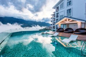 萨帕竹萨帕酒店的酒店游泳池的背景是椅子和山脉