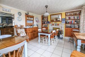 PenpillickVine Cottage的厨房配有桌椅和壁炉。