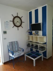 托瑞帕利Casa Papera的客厅配有墙上的时钟和椅子