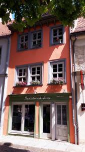 萨勒河畔瑙姆堡Schulmeisterhaus的橙色的建筑,窗户上有鲜花