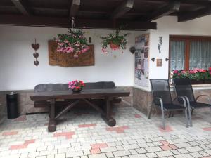 科瓦拉因巴迪亚Garni La Vara的庭院里配有一张带椅子和鲜花的木桌
