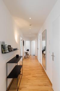 特里尔Casa Augusta - Urban Living的走廊通往带桌子和镜子的客厅
